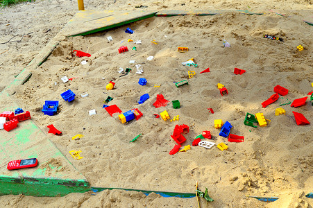 散落着玩具的儿童沙箱童年教育塑料苗圃房子操场盒子太阳假期活动背景图片