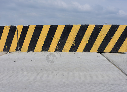黄色和黑色混凝土屏障质地警示材料警告建筑地板条纹背景纹理危害背景图片
