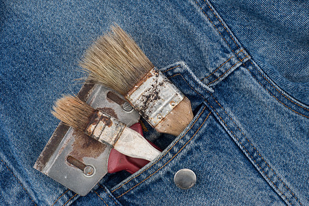 牛仔裤口袋中的油漆刷刷子硬件工具服装爱好画笔工作织物牛仔布作坊背景图片
