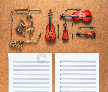 一套五种金色铜管乐器和四种管弦乐器 萨克斯管 小号 圆号 长号 小提琴 大提琴 低音提琴 位于它们之间的中提琴乐谱背景图片