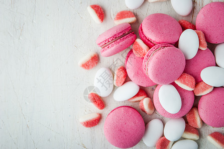 白木桌上的粉红马卡龙和橘子酱杏仁糖果桌子白色红色粉色饼干烘烤背景图片