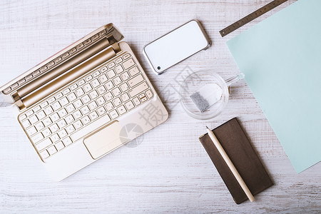 笔记本 电话和地址簿以及木制桌上的杯子电脑包褐色静物作品桌子玻璃键盘木头铅笔白色背景图片