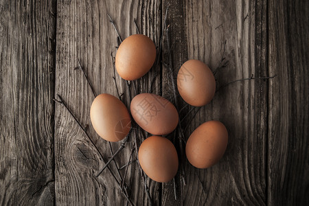 在一张木桌上的鸡蛋营养木板赞成食物桌子褐色灰色静物树枝椭圆形背景图片
