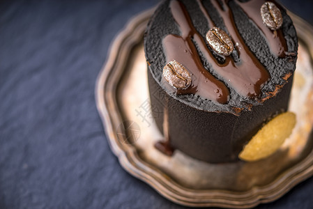 古董盘上的巧克力慕斯糖果部分谷物甜点石头营养石板蓝色静物盘子背景图片
