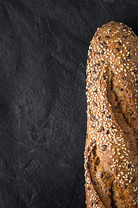 黑石桌垂直背面有谷物和种子的面包背景图片