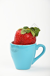 大草莓 蓝色咖啡杯加白色背景图片