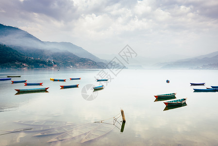肯纳费尼泊尔波克拉的Phewa湖帆船蓝天独木舟风景三桅多云支撑山脉场景钓鱼背景