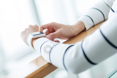 妇女使用智能手表触摸屏配饰屏幕女性电子智力控制技术健康手腕背景图片