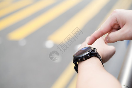 使用智能手表的人街道运动触摸屏工具男性屏幕智力技术手腕腕带背景图片