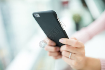 女人拿着电话部门手机上网阅读细胞中心出口女孩购物者开支背景图片