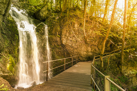 林中一座小瀑布上的木桥背景图片