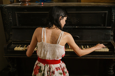 漂亮的黑头发女孩和钢琴背景图片