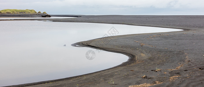 冰岛南部黑色海滩卵石火山海岸线沿海戏剧性岩石海景天空旅游海岸背景图片
