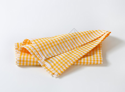 已经检查的茶毛巾折叠抹布黄色茶巾亚麻织物餐巾纺织品背景图片