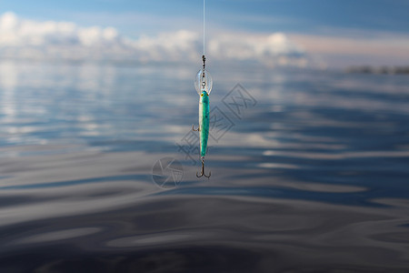 钓鱼线上的贩子海景垂钓者蓝色纺纱鱼钩巨魔绳索诱饵高清图片