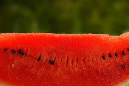 紧贴一小片新鲜红西瓜食物绿色阳光种子红色甜点水果背景图片