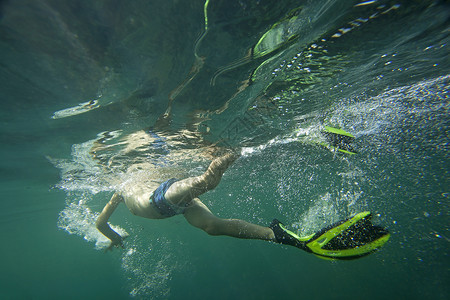 一只潜水器穿梭在飞毛腿的上下方潜水运动游泳气泡潜水员背景图片