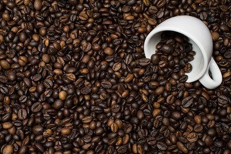 咖啡豆上的白杯背景图片
