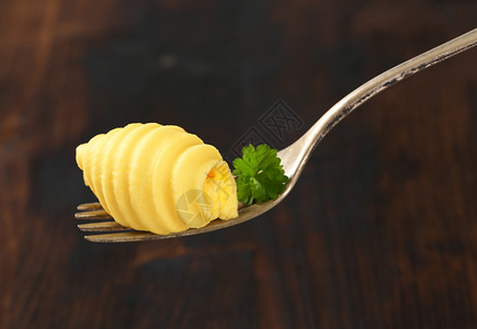 叉子上的黄油卷曲盘食物黄油香菜卷发食品奶制品背景图片