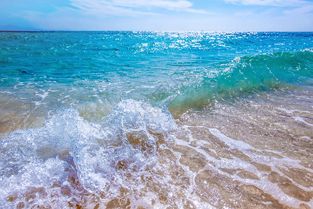 透明青蓝色海浪沙沙滩上的海浪流动热带海岸海滨阳光波纹海洋海岸线天空地平线背景