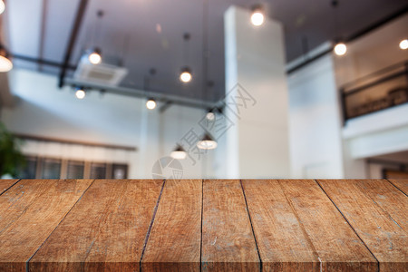 带抽象模糊咖啡厅的透视木桌面背景图片