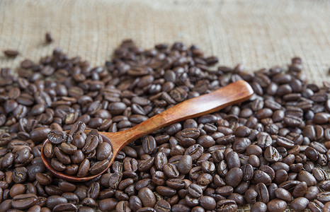 放在麻布上的木勺和咖啡豆烤咖啡豆和木勺种子宏观食物麻布棕色勺子背景