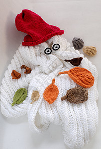 戴红帽子雪人圣诞雪人来自白围巾 红帽子和叶子红帽羊毛团体礼物闲暇工艺帽子眼睛冷天针织帽背景