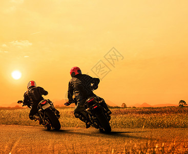 昏暗骑士在沥青高速公路上再次骑自行车的 双胞胎朋友伙伴街道闲暇摩托车手安全情侣头盔夹克男性速度背景