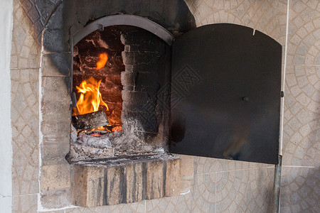 传统林木修道院燃烧火焰黑色金属余烬煤炭壁炉烹饪背景图片