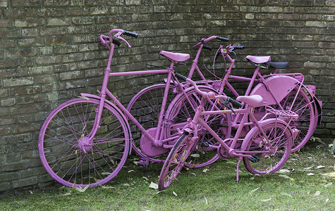 粉粉色油漆的自行车和旧墙壁背景图片