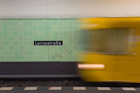 黄色地铁列车在柏林亚历山大广场地下站上开动铁路隧道行动通勤者运动管子交通运输城市车辆背景图片
