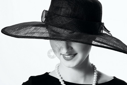 一个穿黑帽子的 年轻女人的近身肖像电话演员幸福接待快照小黑裙裙子古董帽子化妆品背景图片