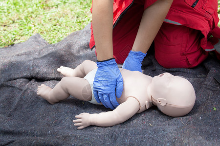 对婴儿假人进行心肺复苏CPR的辅助医疗演示伤口护理人员帮助考试伤害孩子手套疼痛药品训练背景