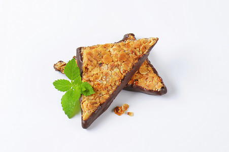 巧克力片三角形坚果棒浸在巧克力中甜点食谱坚果片小吃食物榛子坚果烘焙饼干糕点背景