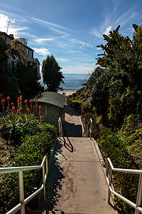 通往肖湾海滩的步骤波浪蓝天假期旅行楼梯背景图片