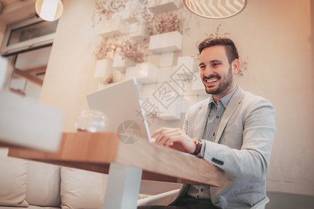 在一个咖啡厅工作笔记本咖啡店享受商业水平互联网微笑技术男人电脑背景图片