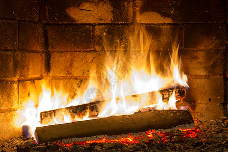 在壁炉里烧柴火 紧闭着煤炭烧伤黑色红色活力橙子营火日志黄色火焰背景图片