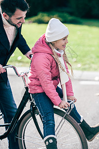 爸爸骑车带孩子父亲骑自行车带着笑着女儿的父亲背景