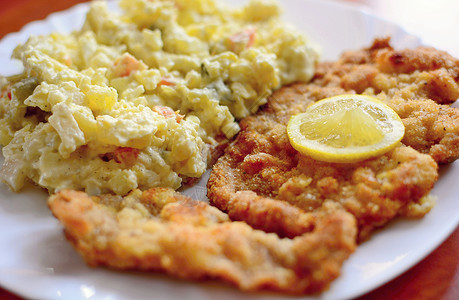 炒猪肉肉饼午餐沙拉鱼片柠檬油炸食物牛扒土豆白色盘子背景图片