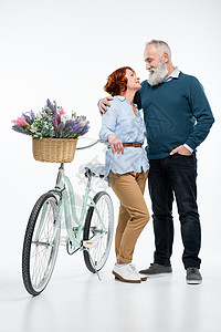 带自行车的成熟夫妇中年拥抱女士胡子两个人友谊男人花朵夫妻篮子背景图片