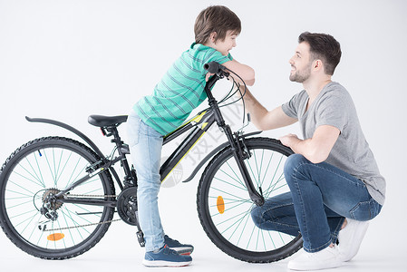 父亲在白色自行车上与儿子交谈的一面运输成人水平微笑背景图片