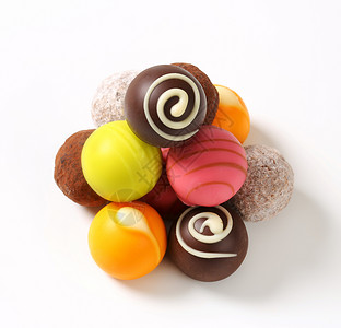 各种巧克力松露和菠萝甜点棕色糖果水果粉色奶糖味道橙子杏仁绿色背景图片