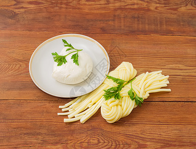 新疆拉条两品种的莫扎雷拉奶酪 和木质表面面食谱上的鹦鹉美食盐水奶制品飞碟农业厨房食物小枝香菜芝士背景