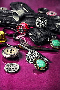 紫色背景的缝纫配件爱好工作室剪刀配饰金属工具乐器女裁缝裁缝顶针背景图片