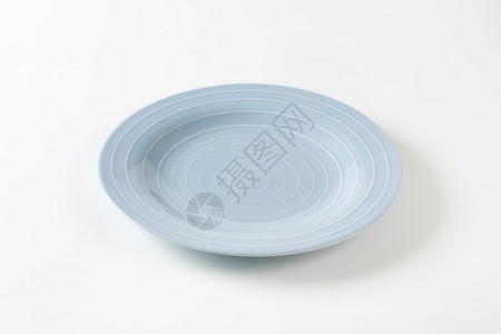 蓝餐盘制品陶器陶瓷盘子浅蓝色餐具同心圆蓝色浮雕圆形背景图片