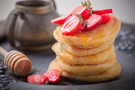 糖煎饼堆满草莓和蜂蜜蛋糕食物糖浆黄油甜食早餐背景图片