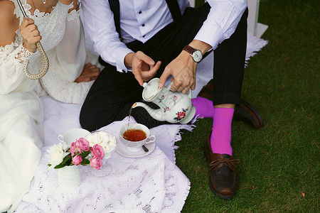 绿色草地上鲜亮衣服的新娘和新郎茶壶野餐女性女孩婚姻妻子幸福夫妻男人女士背景图片
