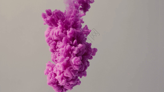 墨水中掉落的彩色背景气泡流动灰色紫色液体浅色背景图片