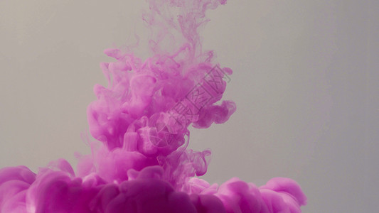 墨水中掉落的彩色液体紫色流动浅色背景气泡灰色背景图片
