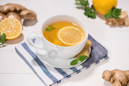 木制桌上的健康的姜茶成分玻璃饮料蓝色木头叶子薄荷水果杯子水烟白色背景图片